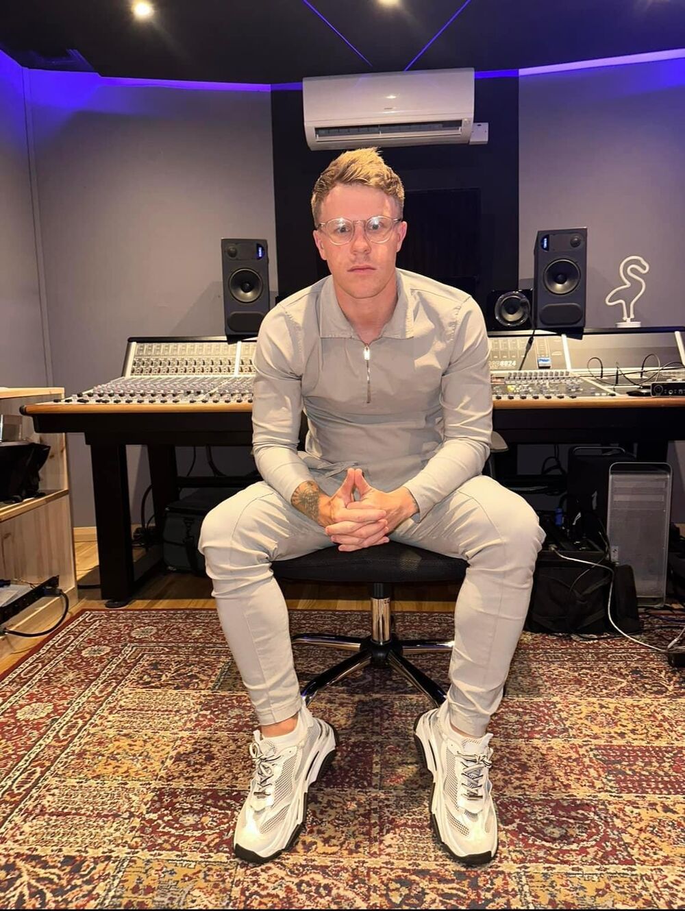 Nathan Grisdale seated at a mixing desk in a recording studio