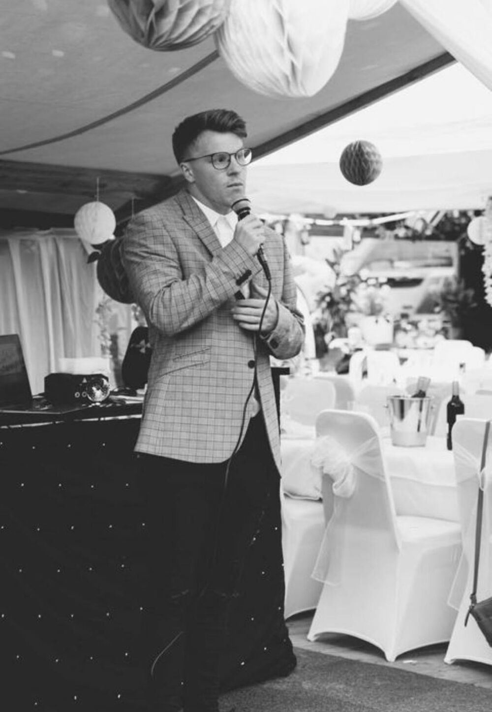 Nathan Grisdale singing into a microphone at a wedding reception