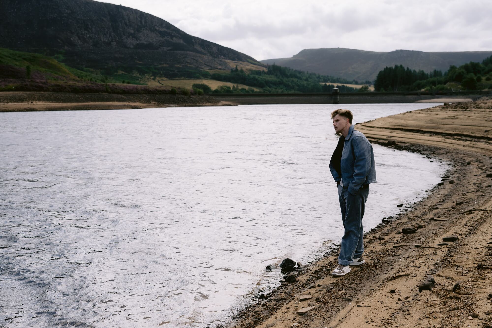 Nathan Grisdale at the edge of a reservoir in the hills